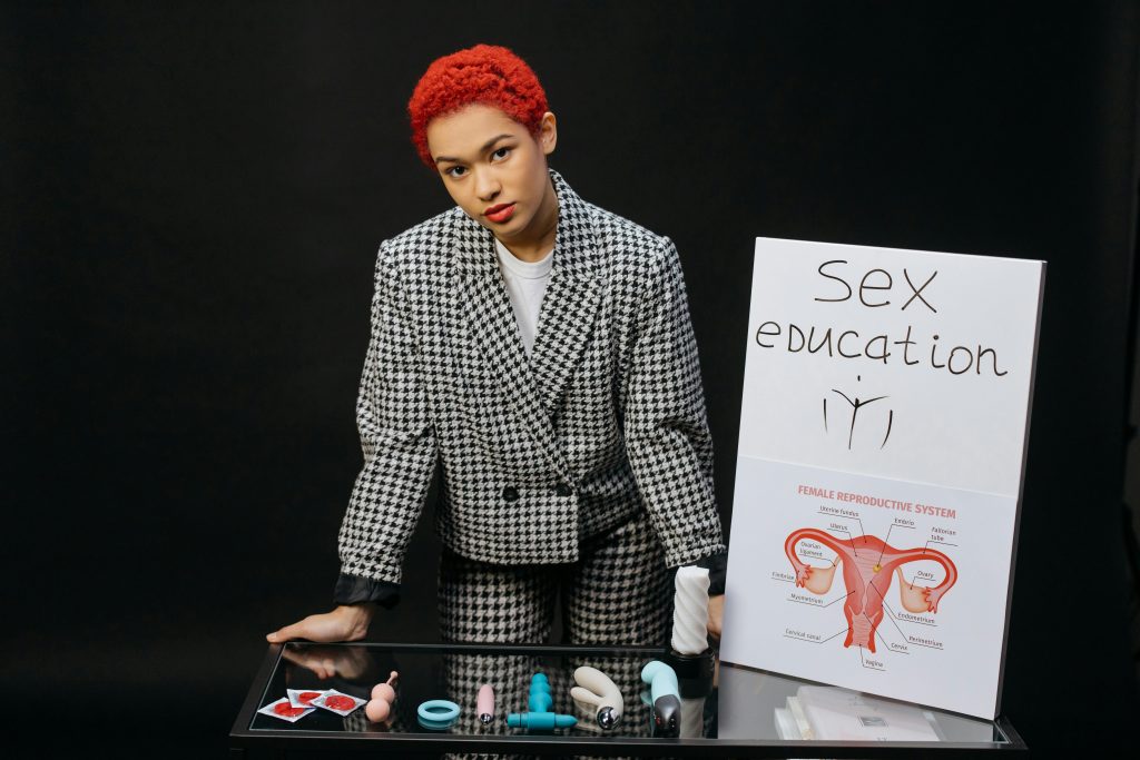 woman with sex ed sign and table of sex toys